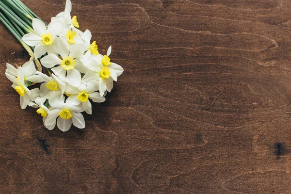 stock image A bouquet of daffodils lies on a wooden background