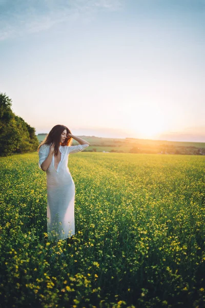 Menina andando no campo ao pôr do sol — Fotografia de Stock