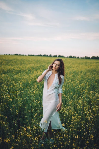 Menina andando no campo ao pôr do sol — Fotografia de Stock