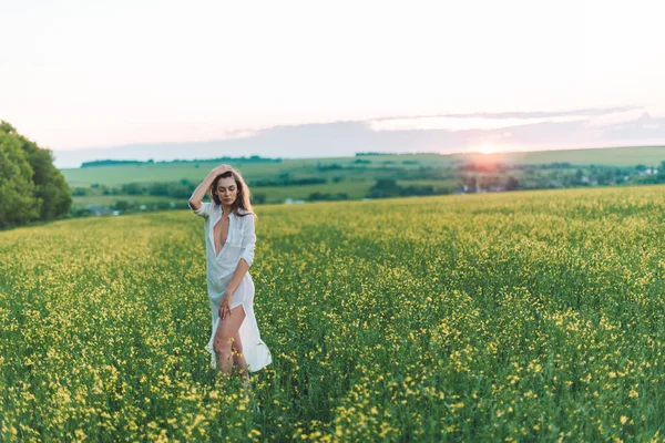 Menina andando no campo ao pôr do sol — Fotografia de Stock