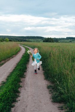 Bir çocuk papatyalar Çizmeli bir buket ile çalışır
