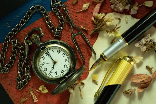 Reloj de bolsillo vintage y lápiz de latón en el libro viejo . — Foto de Stock