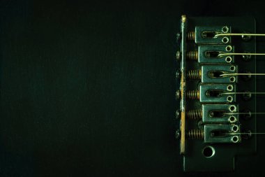 Yakın plan pas köprüsü ipi bağlamaya ya da sıkmaya yarar. Karanlıkta siyah elektro gitar. Üst görünüm ve boşluk kopyala. Geçmişe dönük müzik enstrümanları ve rock müziği hakkında iyi bir anı kavramı.