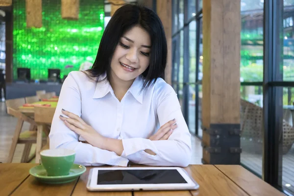 Mujer mirando tableta con una taza de café —  Fotos de Stock