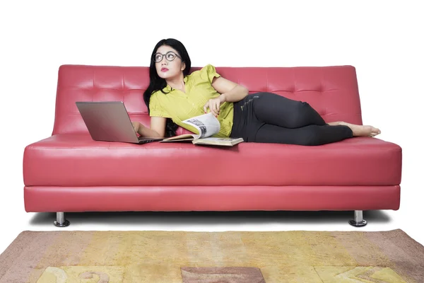 Donna in cerca di idee sul divano rosso — Foto Stock