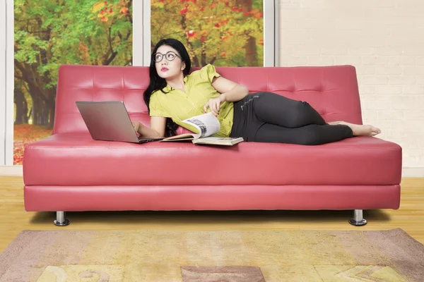 Женщина думает что-то на диване — стоковое фото