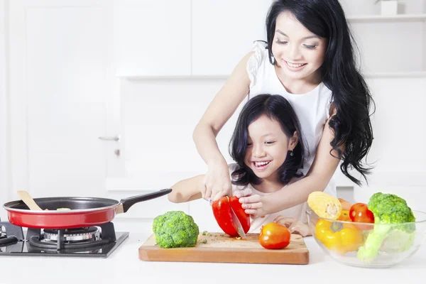 Söt flicka och mor skära paprika — Stockfoto