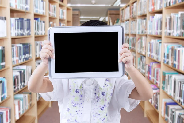 Uczeń szkoły podstawowej z tabletem w bibliotece — Zdjęcie stockowe