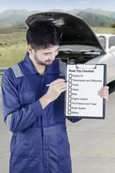 Mecánico sostiene consejos de viaje por carretera en la calle —  Fotos de Stock