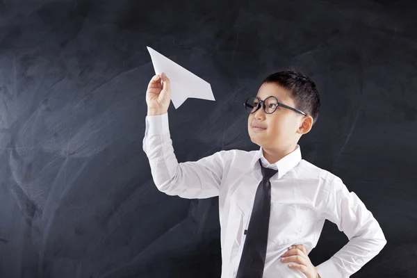 Schoolboy holds paper plane — Stock Photo, Image