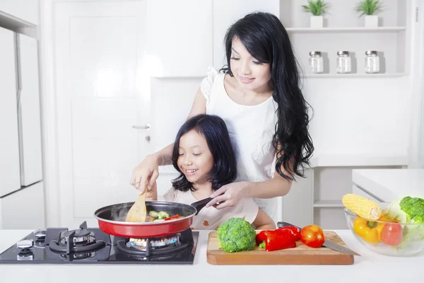 Mulher e filha cozinhar vegetal — Fotografia de Stock