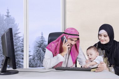 Oturma odasında oturan Arap aile