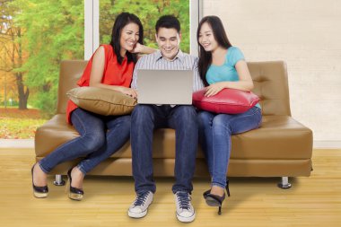 Dizüstü bilgisayar oynayan üç kişi