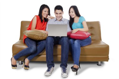 Kanepede üç öğrenci ve dizüstü bilgisayar