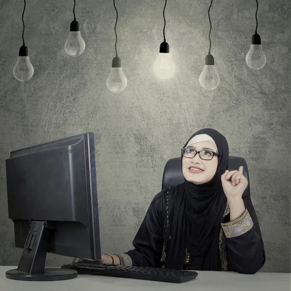 Mulher árabe pensando em ideia sob bulbo — Fotografia de Stock