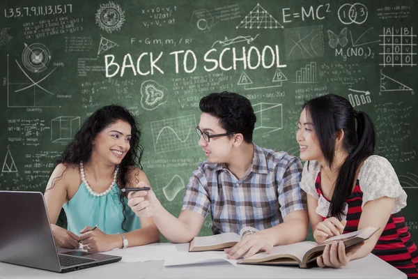 Estudiantes discutiendo asignación en la clase — Foto de Stock