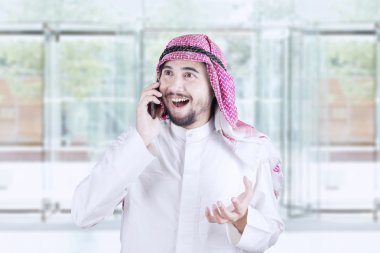Mutlu Arap adam cep telefonu konuşuyor
