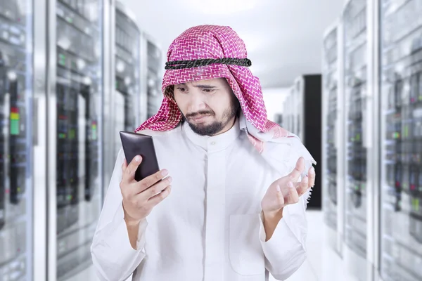 Arábiai ember olvas üzenetet szerver szobában — Stock Fotó