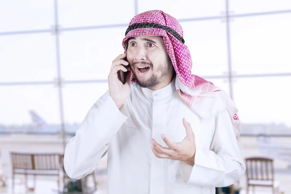 Arábiai férfi beszél cellphone a repülőtéren — Stock Fotó