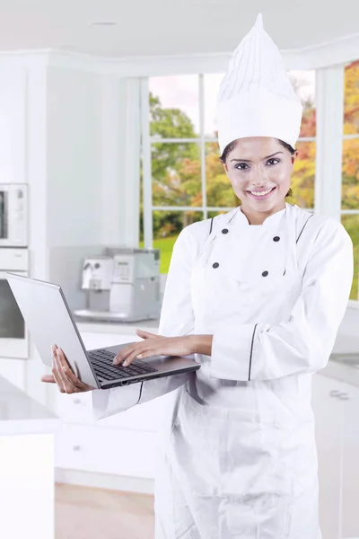 Gourmet using laptop in the kitchen — Stock Photo, Image