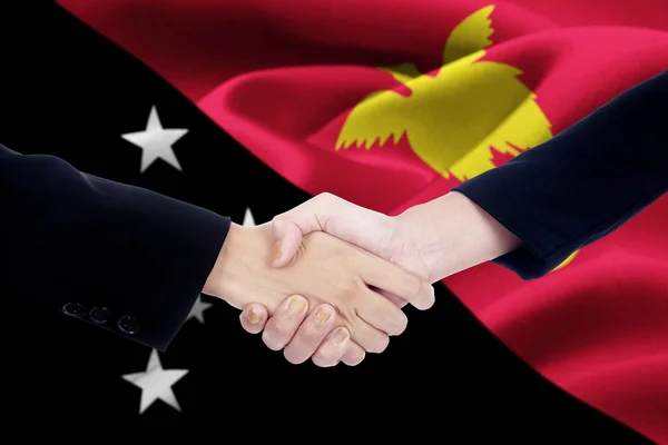 Händedruck mit der Flagge von Papua Neuguinea — Stockfoto