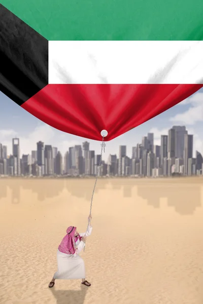 El hombre tira de la bandera nacional de Kuwait — Foto de Stock