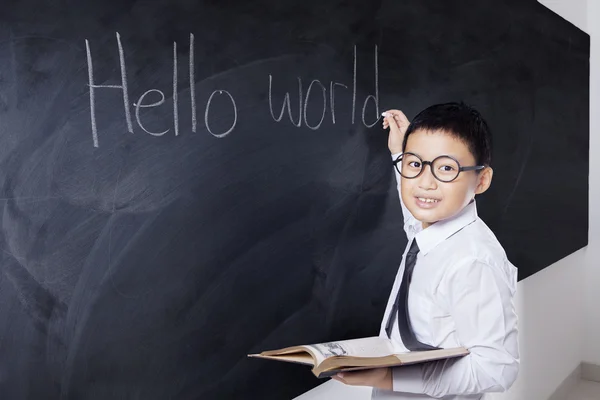 Junge hält Buch und schreibt Hallo Welt — Stockfoto