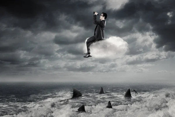 Бізнесмен з біноклями сидить на хмарі — стокове фото