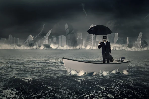 Businessman with umbrella in boat — Stock Photo, Image