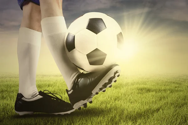 Piede del giocatore di calcio e palla sull'erba — Foto Stock