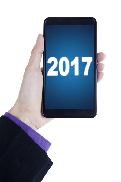 Mano con teléfono móvil y 2017 — Foto de Stock