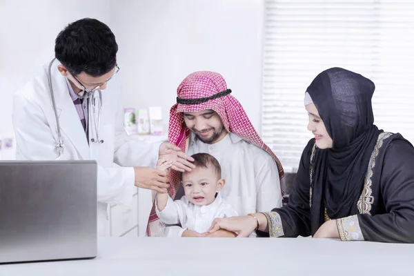 Los padres árabes y el niño pequeño visitando al médico —  Fotos de Stock