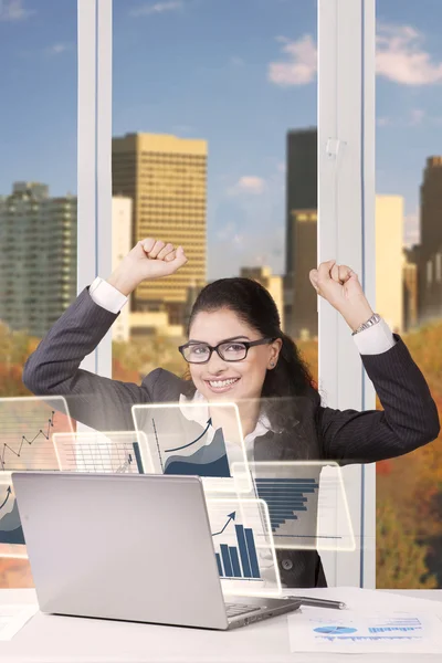 Businesswoman with arms up and a laptop — Stockfoto