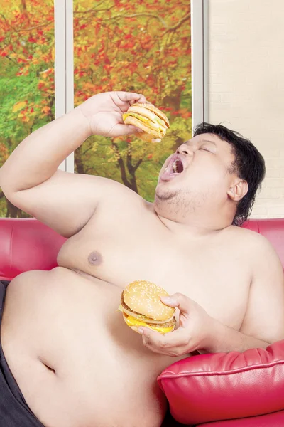 Sobrepeso com dois grandes hambúrgueres — Fotografia de Stock