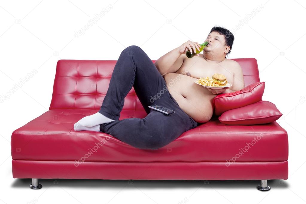 Overweight man reclining on couch