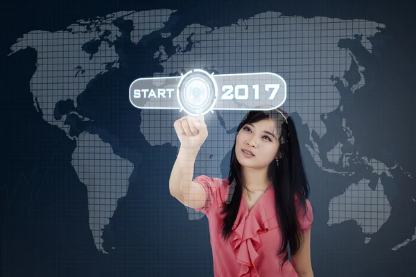 Mujer asiática presionando el botón de inicio con 2017 — Foto de Stock