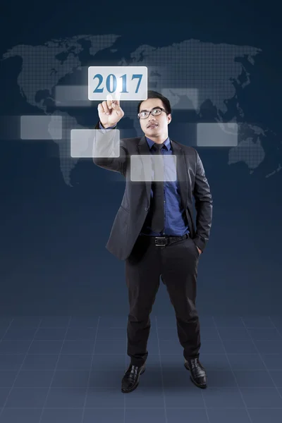 Uomo d'affari premendo numeri virtuali 2017 — Foto Stock