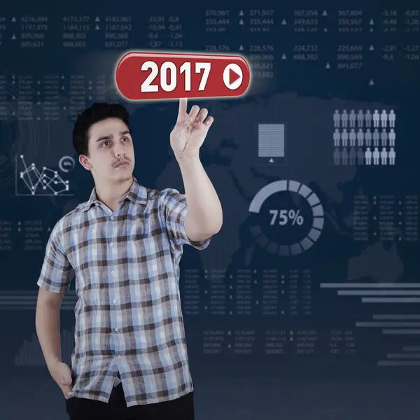 Caucasian man presses button with 2017 — Stock Photo, Image