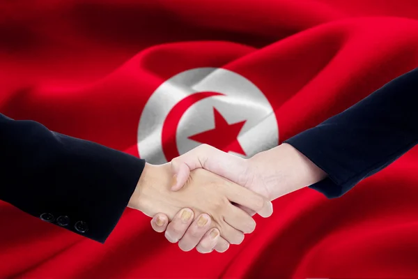 Equipe de negócios apertando as mãos com a bandeira da Tunísia — Fotografia de Stock