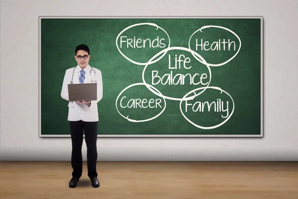 Doctor with laptop and text of life balance — Stockfoto