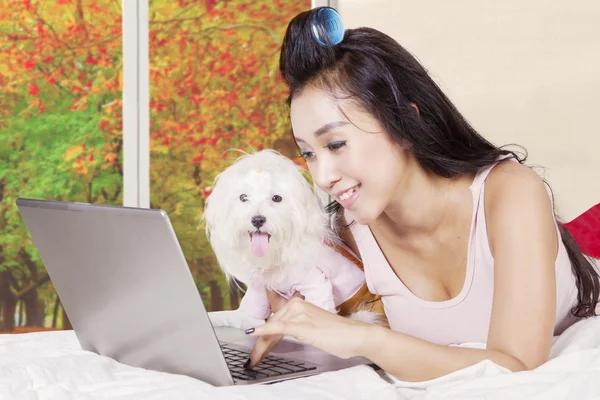 Женщина и собака играют на ноутбуке в осенний сезон — стоковое фото
