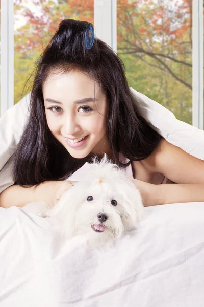 Donna che tiene il cane carino sotto coperta — Foto Stock