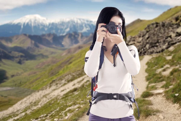 Женщина фотографирует цифровым фотоаппаратом — стоковое фото