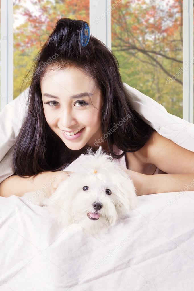 Woman holding cute dog under blanket