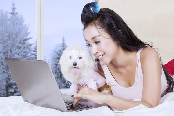 Frau mit Hund spielt Laptop im Schlafzimmer — Stockfoto