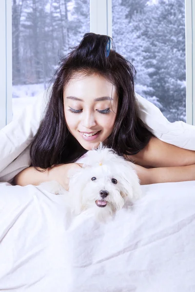 Frau und Hund liegen unter Decke — Stockfoto