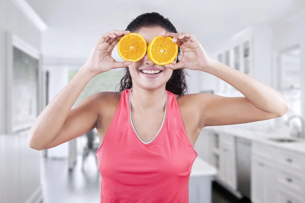 アジア女性はオレンジの 2 つのスライスを保持します。 — ストック写真