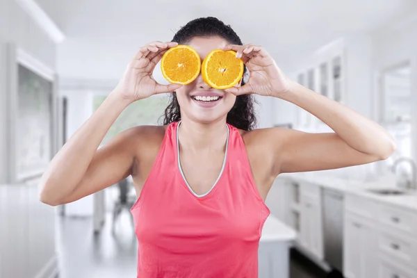 Femme asiatique tient deux tranches d'orange — Photo