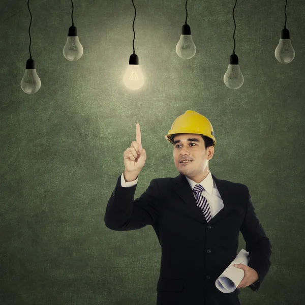 Businessman pointing at light bulb — Stock Photo, Image