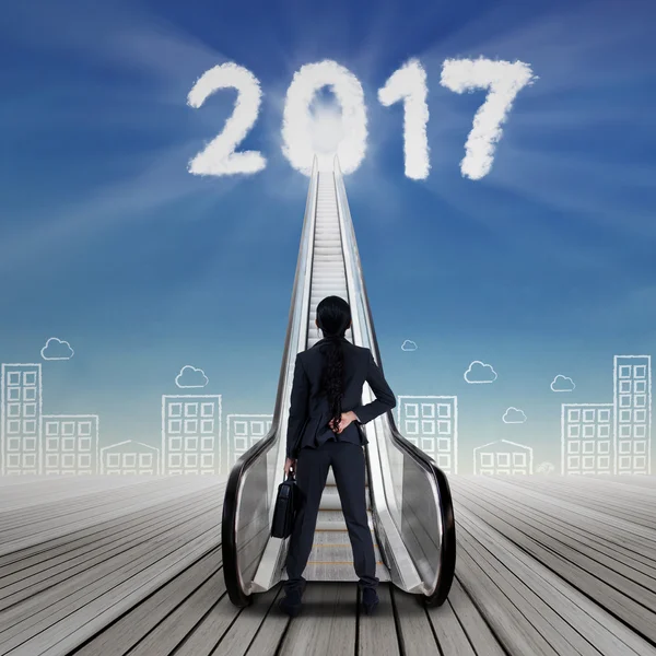 Geschäftsfrau mit Nummer 2017 und Rolltreppe — Stockfoto